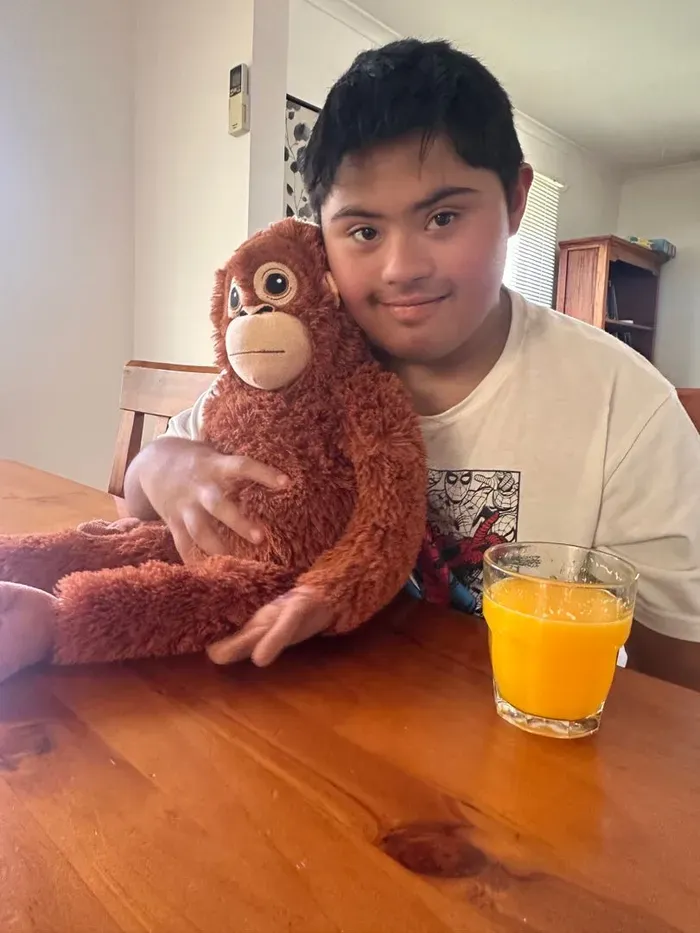A participant relaxing at home with a favourite plush toy and a glass of juice